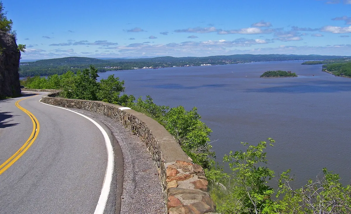 Storm King Highway curving along a stone wall on the cliff above the Hudson River and Newburgh Bay