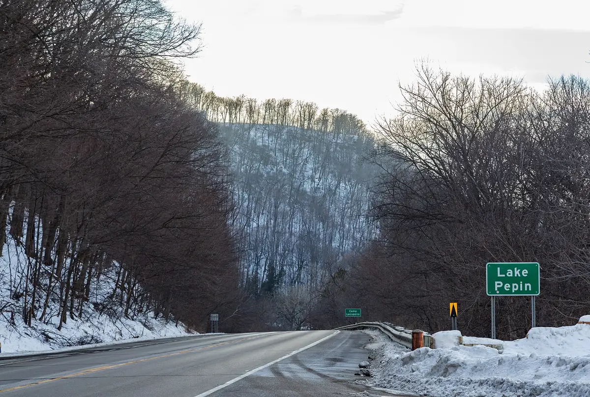 US 61 running through a snowy bluff valley beside Lake Pepin in Minnesota