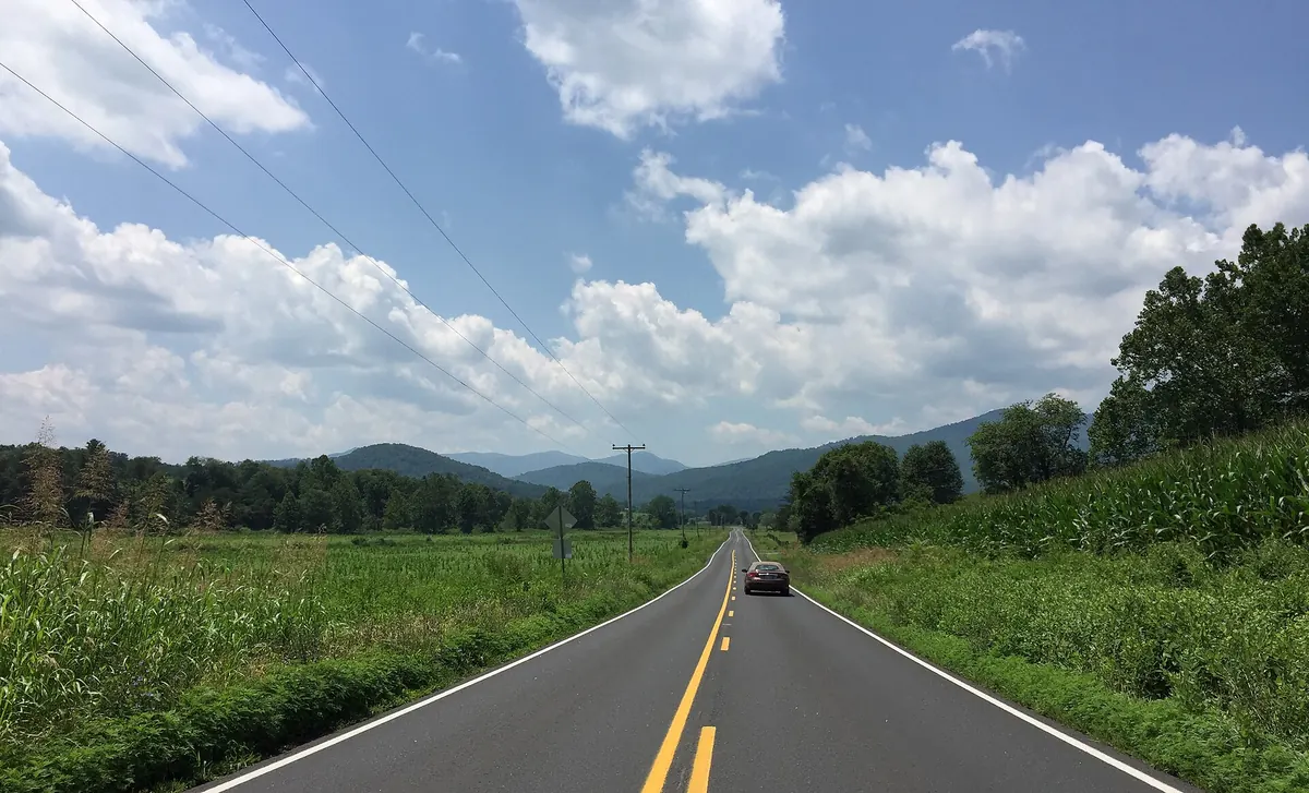 Two-lane Virginia Route 231 running through cornfields toward the Blue Ridge foothills near Etlan